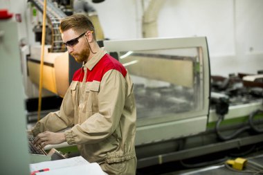 Makine fabrikada çalışan yakışıklı genç