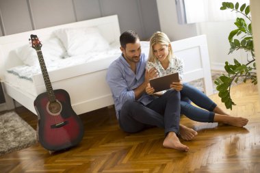 Tablet el ile katta oturan genç Çift