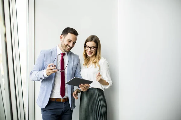 Compañeros Negocios Felices Oficina Moderna Usando Tableta Contra Pared — Foto de Stock