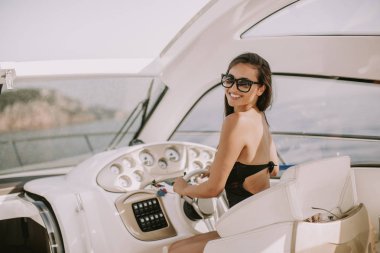 Genç çekici kadın bir yat denizde güneşli gün sürücüleri