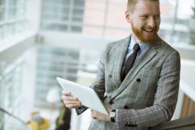 Office merdivenlerde tablet kullanarak kendine güvenen işadamı portresi