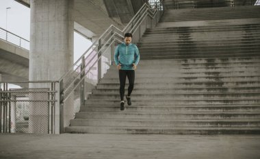 Hızlı açık havada şehirde koşan genç adam