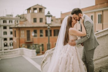 Genç çekici yeni evli çift ile güzel ve antik mimari planda Roma'da poz