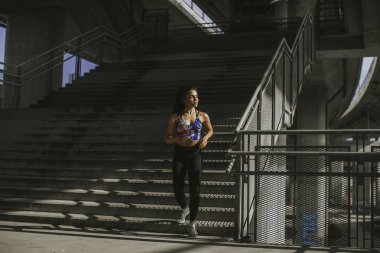 Şehir ortamında koşan güzel genç bir kadın.