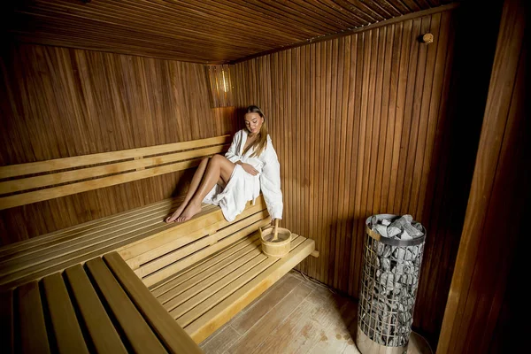 Pretty young woman relaxing in the sauna