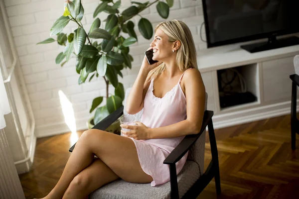 Jovem Mulher Usando Telefone Celular Segurando Vidro Água Enquanto Está — Fotografia de Stock