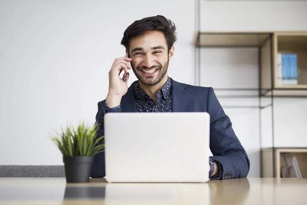 Jovem Empresário Trabalhando Laptop Falando Telefone Celular Escritório Moderno — Fotografia de Stock