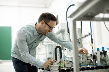 Elektronik atölyesinde yakışıklı genç adam portresi