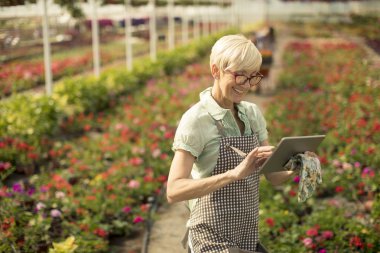 Tablet çiçek garde içinde kullanma kadın kıdemli portresi