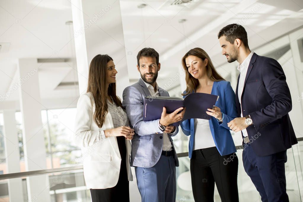 Young business people standing and analyzing documents in office