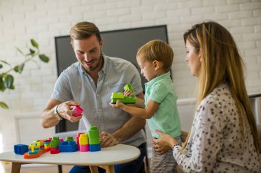 Küçük çocuk oyuncakları anne ve babayla modern evde oynarken