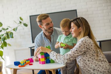 Küçük çocuk oyuncakları anne ve babayla modern evde oynarken