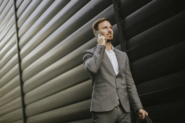 Красивый Молодой Бизнесмен Идет Мобильным Телефоном Перед Офисным Зданием — стоковое фото