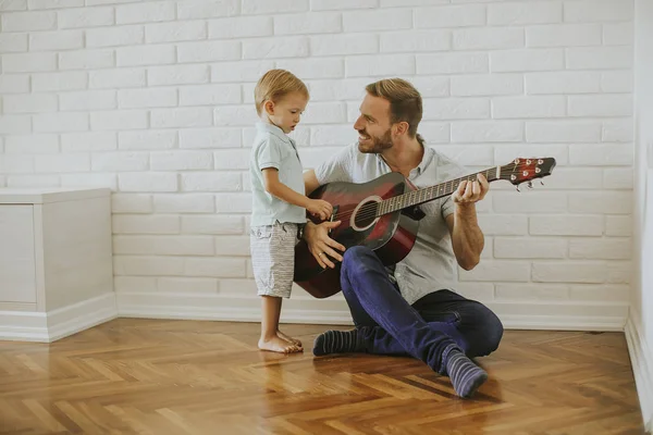 Father and little son with guitar at home