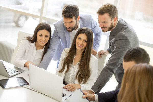 Startup business team on meeting in modern bright office interior and working on laptop
