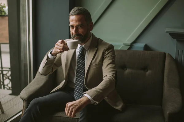 Guapo Elegante Hombre Negocios Serio Sentado Sillón Sosteniendo Taza Café — Foto de Stock