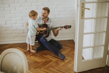 Baba ve küçük oğul evde gitar ile