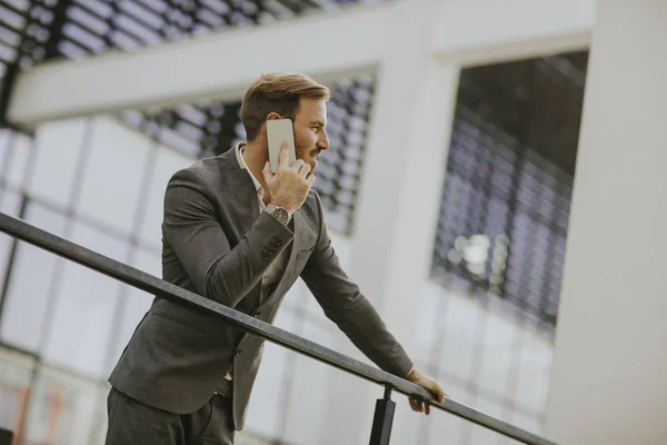 Jovem Empresário Sucesso Vestindo Terno Cinza Segurando Seu Smartphone Enquanto — Fotografia de Stock