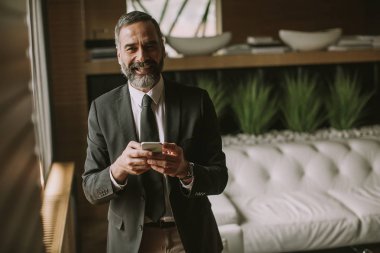 Cep telefonu kullanma modern office üst düzey yakışıklı işadamı portresi