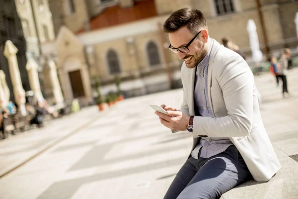 Utomhus Porträtt Glad Ung Man Med Mobiltelefon Sitter Vid Solig — Stockfoto