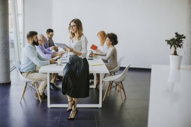 Genç çekici kadın Yöneticisi duran modern Office dijital tablet üzerinde çalışan