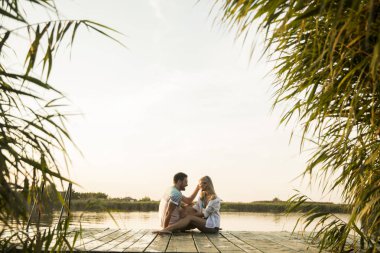 Ahşap iskele göl güneşli gün oturup romantik çift