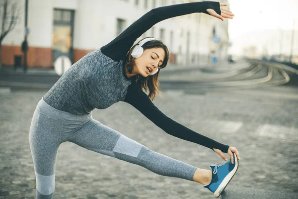 Genç kadın uygulamaları açık koşu sonra germe, görüntüleme