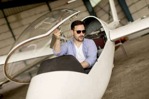 英俊的年轻飞行员检查飞机机库 — 图库照片