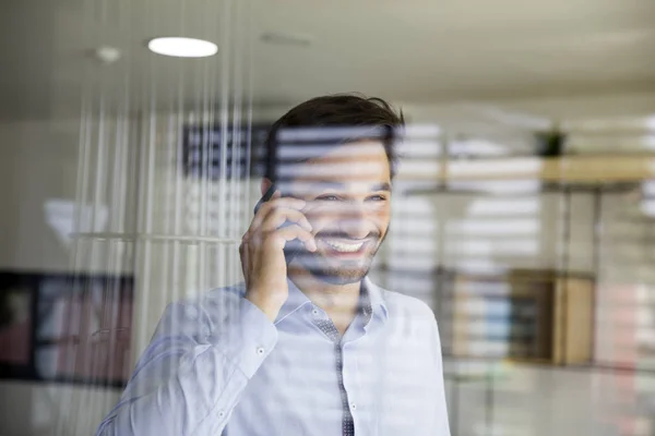 Bello Giovanotto Usando Cellulare Dietro Vetro Ufficio — Foto Stock