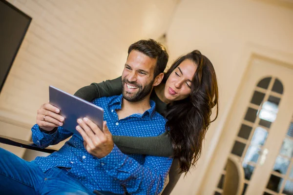 Portrait Jeune Couple Assis Dans Salon Utilisant Une Tablette Numérique — Photo