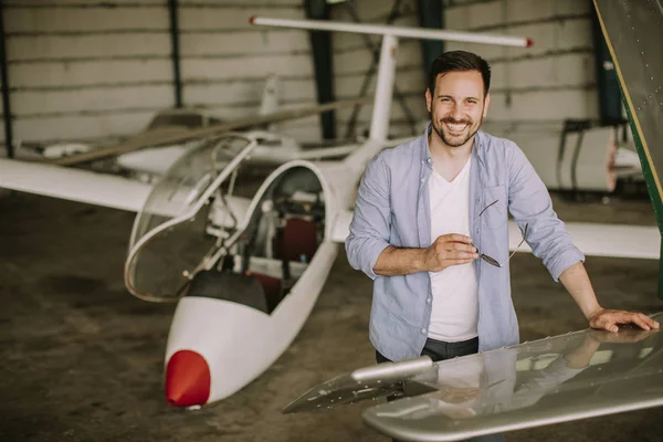 Jovem Piloto Bonito Verificando Avião Hangar — Fotografia de Stock