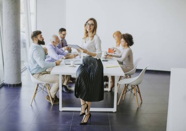 Genç çekici kadın Yöneticisi duran modern Office dijital tablet üzerinde çalışan