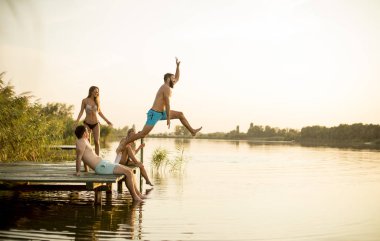 Bir grup genç insan sıcak hummer gün gölde iskelenin üzerinde eğlenceli olması