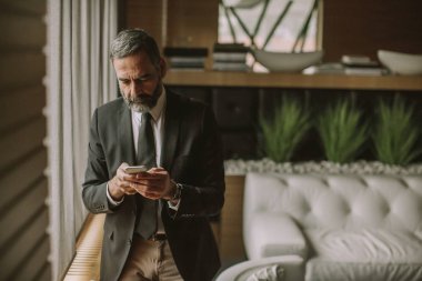 Cep telefonu kullanma modern office üst düzey yakışıklı işadamı portresi