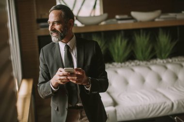 Cep telefonu kullanma modern office üst düzey yakışıklı işadamı portresi