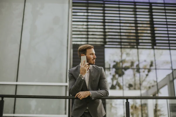 Jovem Empresário Sucesso Vestindo Terno Cinza Segurando Seu Smartphone Enquanto — Fotografia de Stock