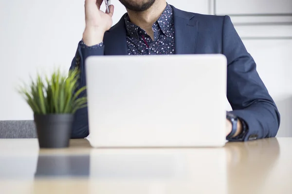 Jovem Empresário Trabalhando Laptop Falando Telefone Celular Escritório Moderno — Fotografia de Stock