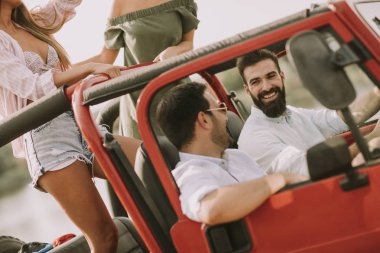 Mutlu arkadaşlar eğlenmeye Cabrio araba tatil nehir kenarında