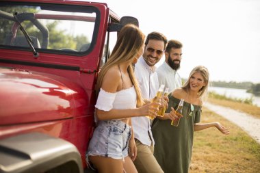 İçme ve eğlenmek arabayla sıcak yaz gününde açık gençler