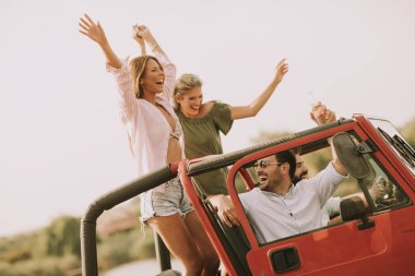 Mutlu arkadaşlar eğlenmeye Cabrio araba tatil nehir kenarında