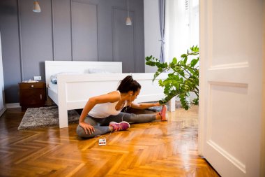 Genç ve güzel kadın egzersiz odasında yerde yapmak