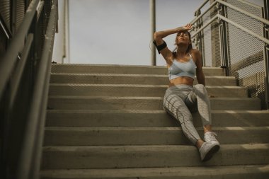 Merdivenlerde istirahat oldukça genç kadın atlet portresi