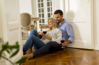 Sevgi dolu çift birbirine evde kırmızı şarap içme bakarak