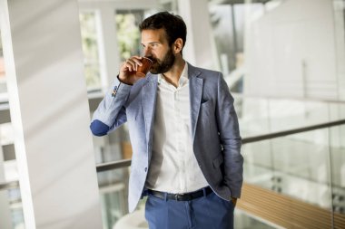 İş adamı bir takım elbise ve bir fincan kahve bir ofis binası.