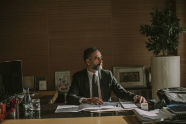 Modern ofis masasında çalışan üst düzey iş adamı