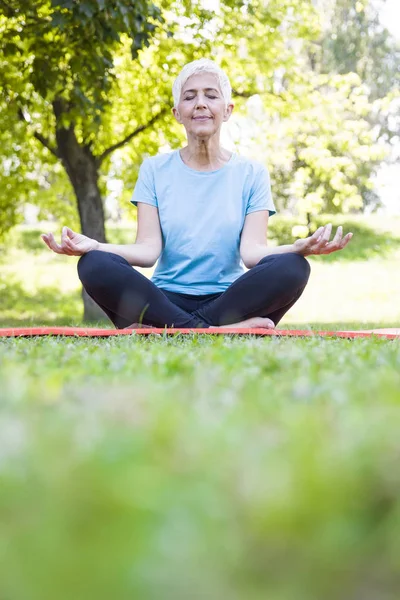 Seniorin Lotus Pose Sitzt Sommertag Auf Grünem Gras — Stockfoto