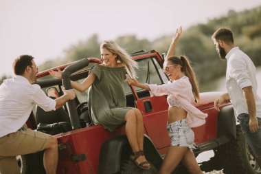 Nehir kenarındaki Cabrio araba içinde eğleniyor dört gençler