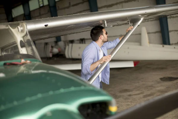 Jovem Piloto Bonito Verificando Avião Hangar — Fotografia de Stock