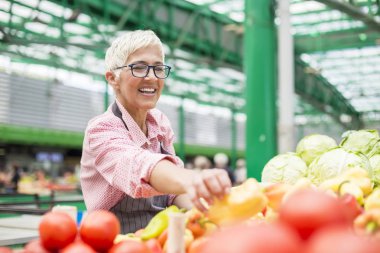 Kadın kıdemli organik sebze piyasasında satıyor