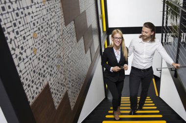 Modern ofis merdivenlerden yukarı tırmanırken genç iş adamları, görüntüleme